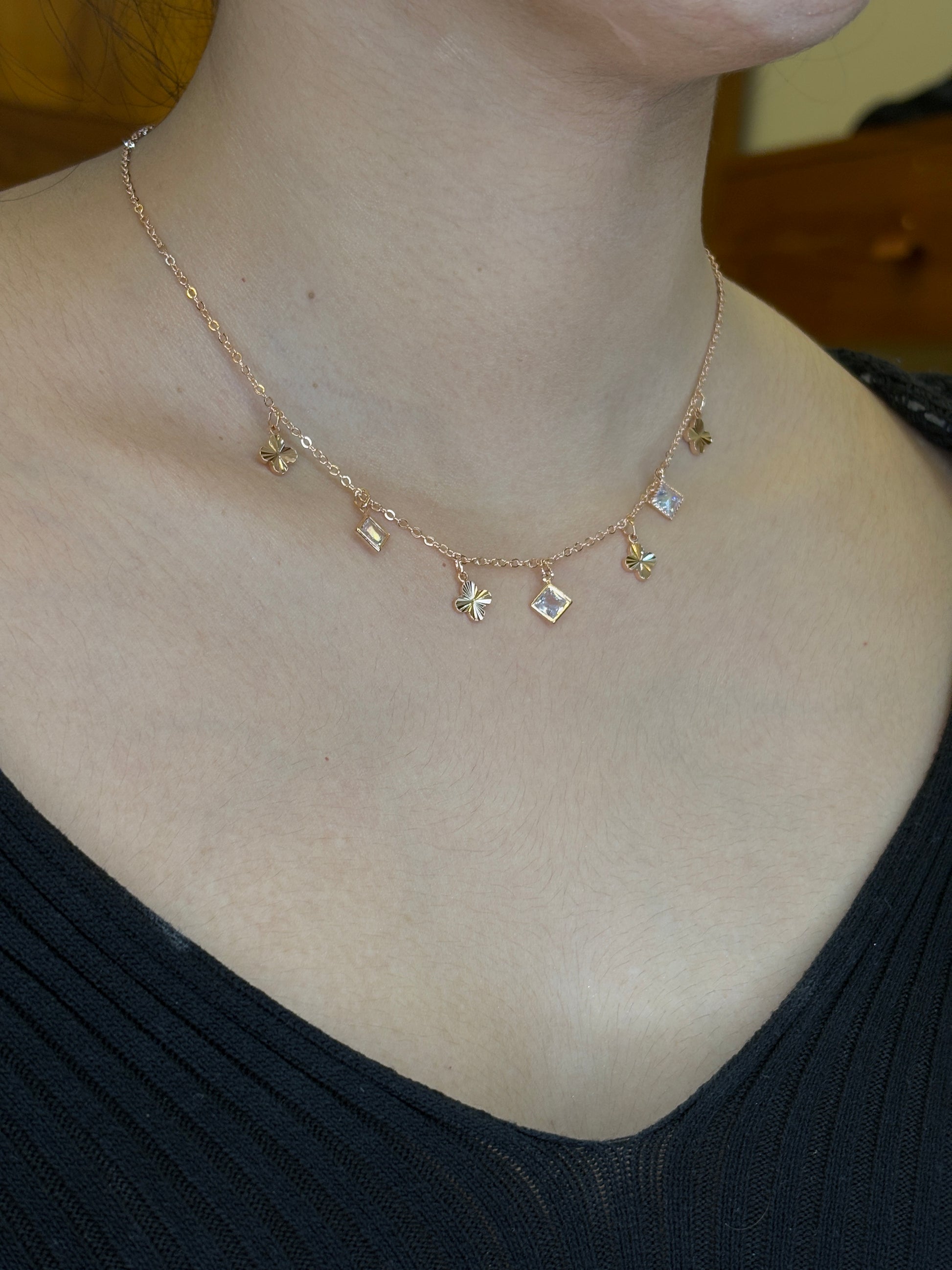 Gold necklace with star and heart pendants on a person's neck